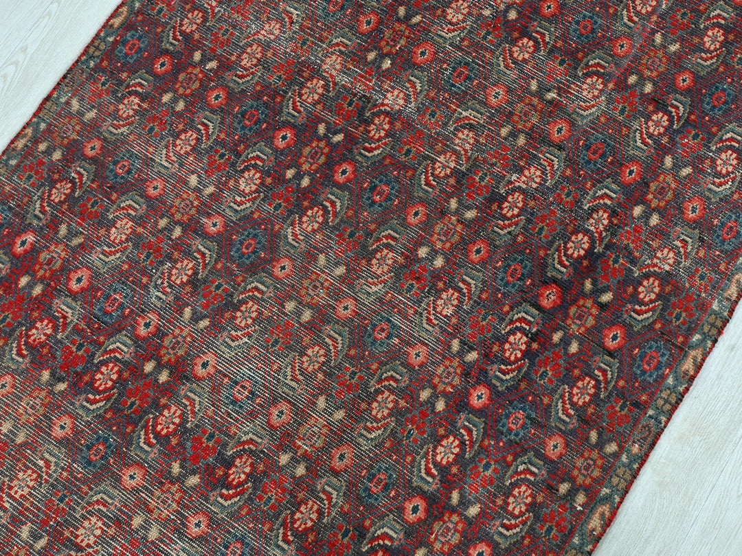 a red and blue rug on a wooden floor