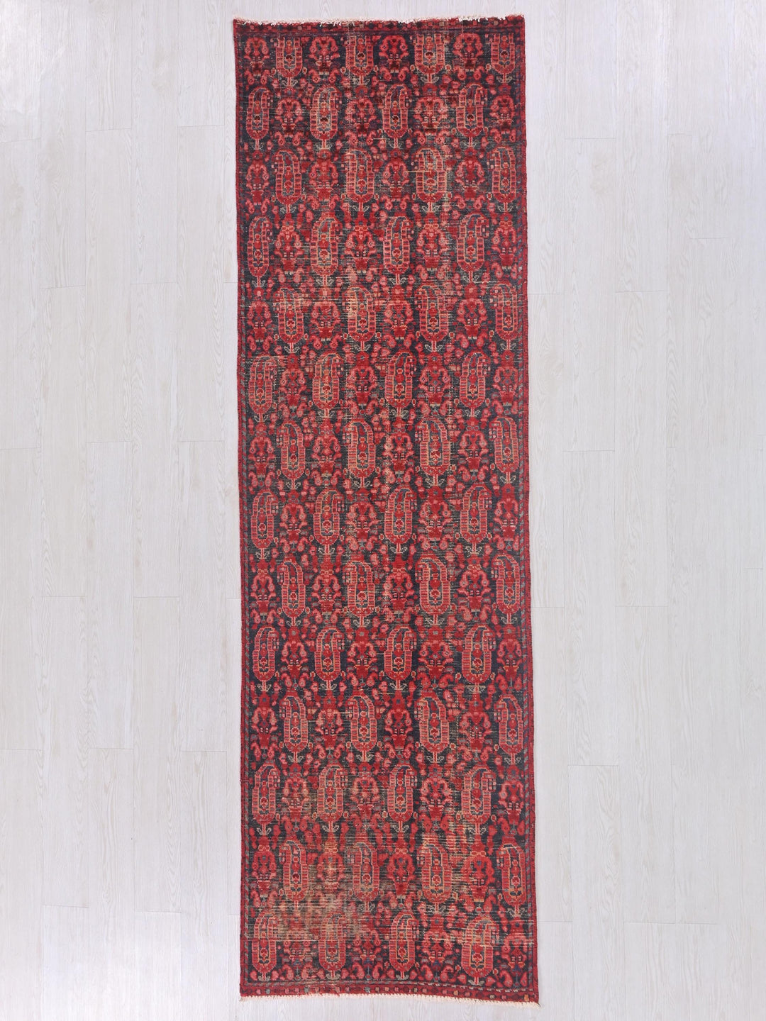 a red and black rug on a white floor