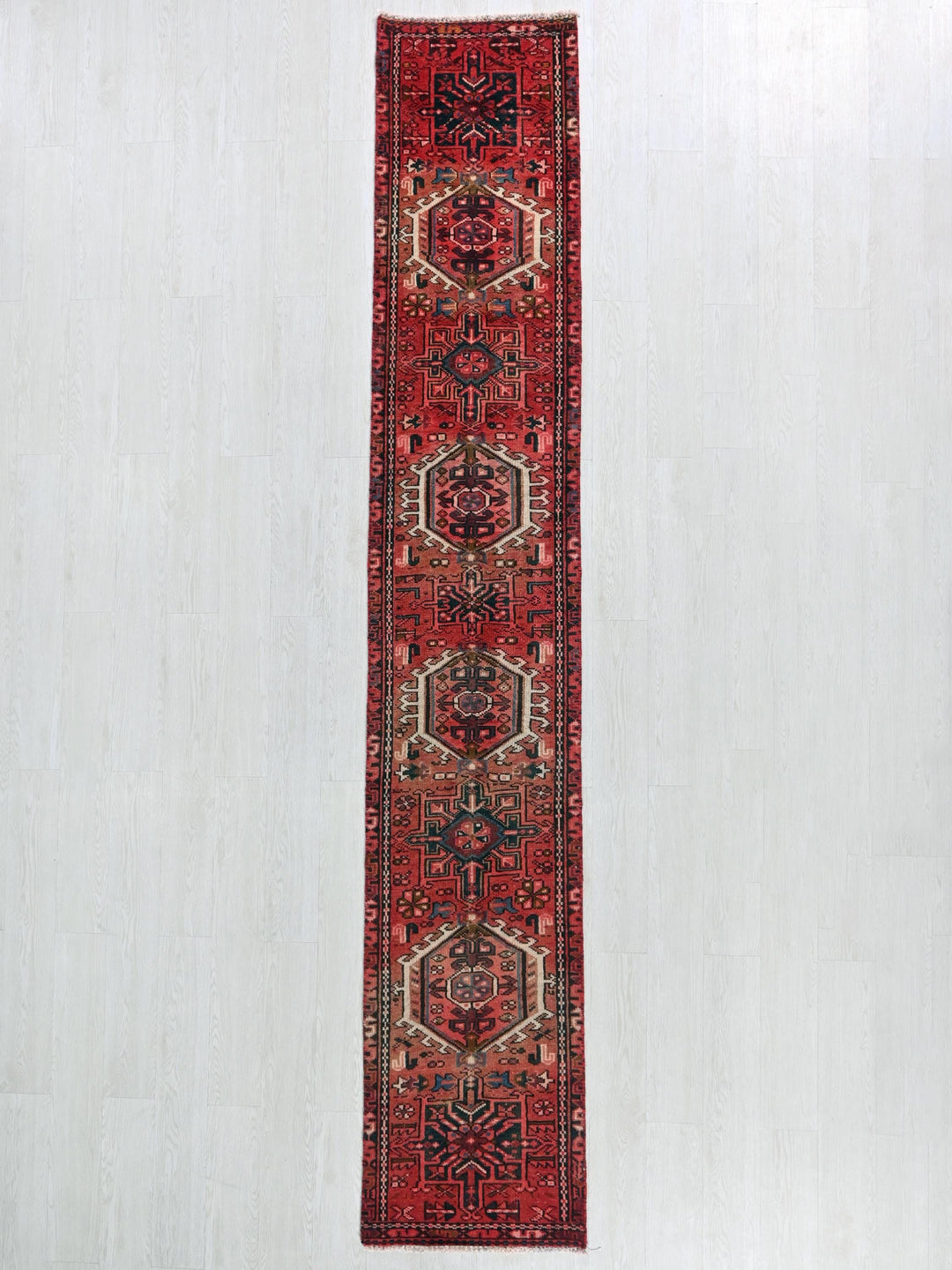 a red runner rug hanging on a wall