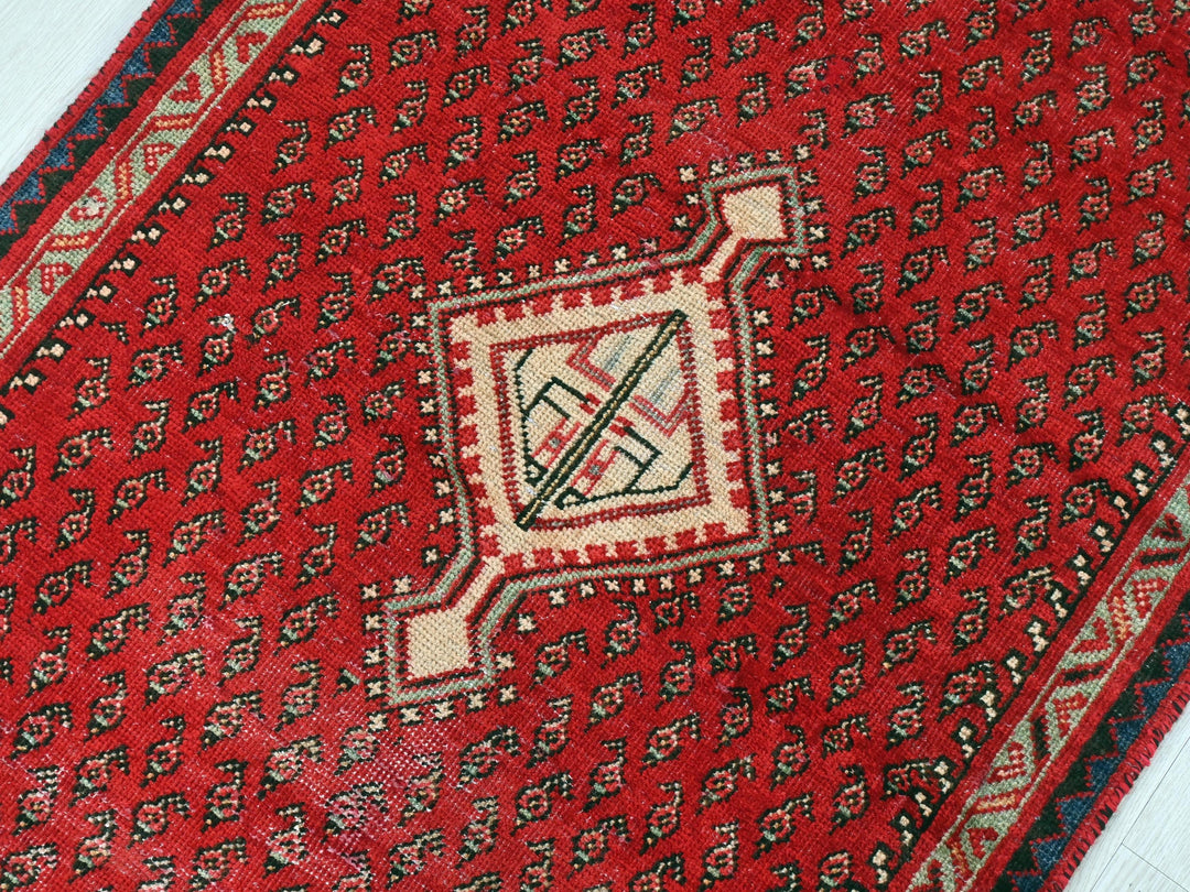 a close up of a red rug on a wooden floor