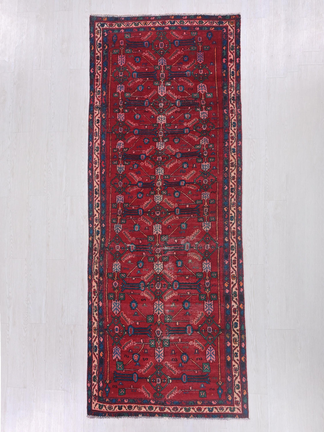 a red rug with a design on the middle of it