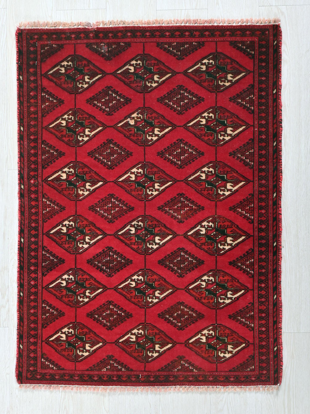 a red rug with a diamond pattern on it