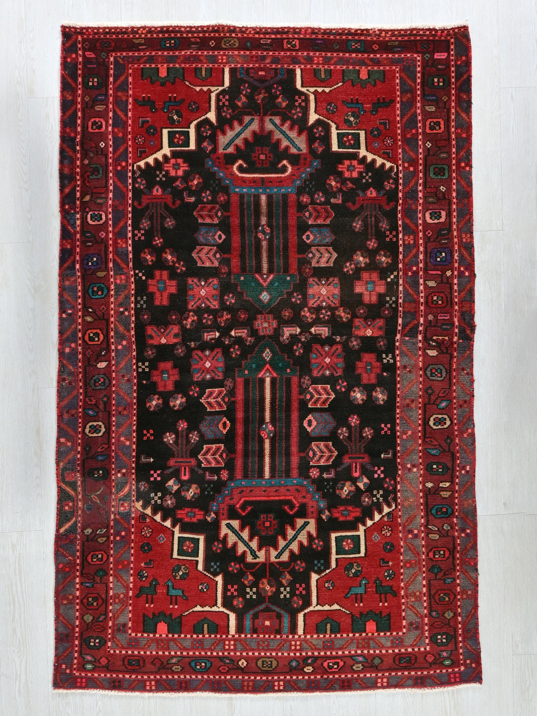 a red and black rug on a white floor