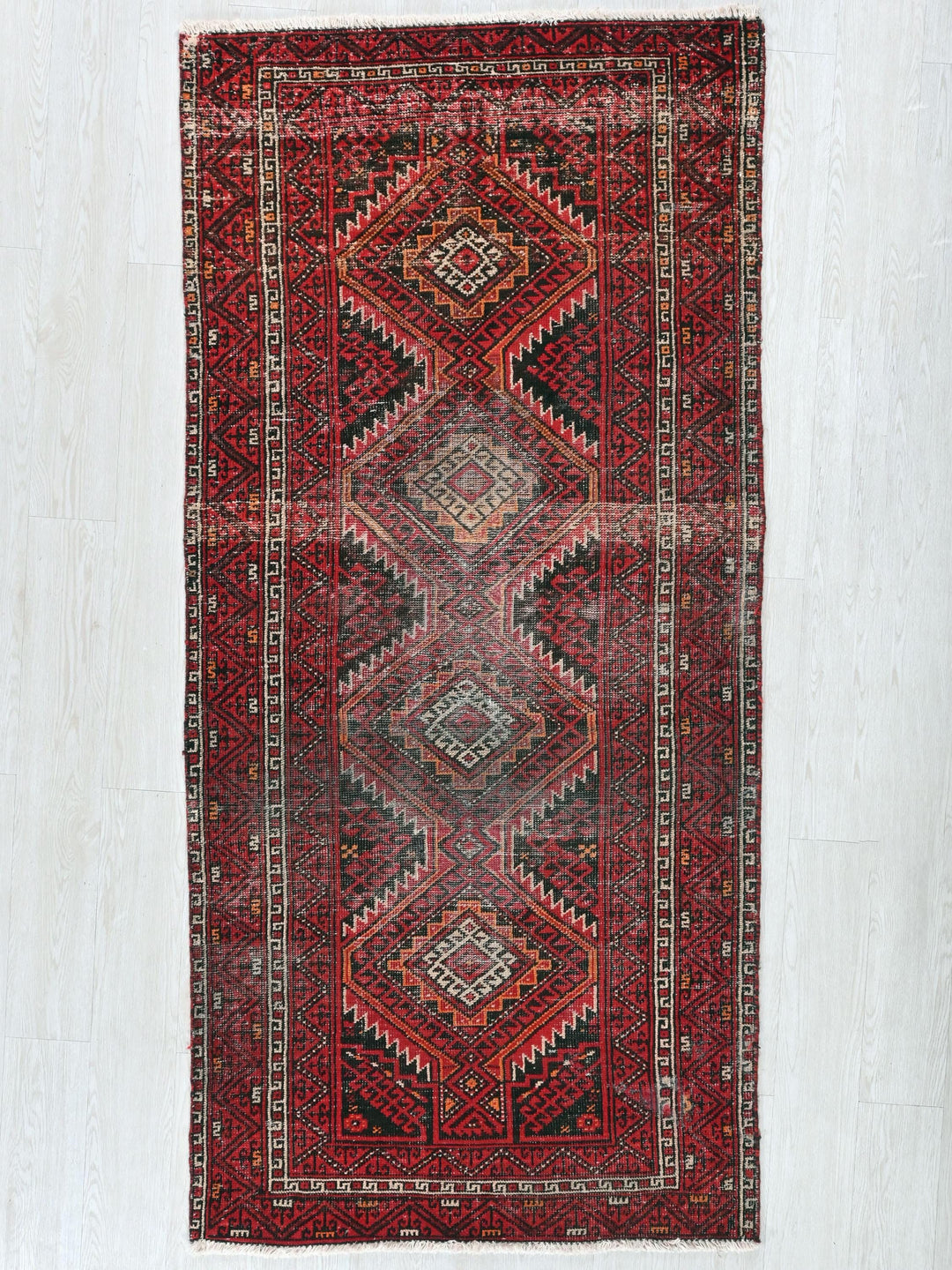 a red rug with a diamond pattern on it