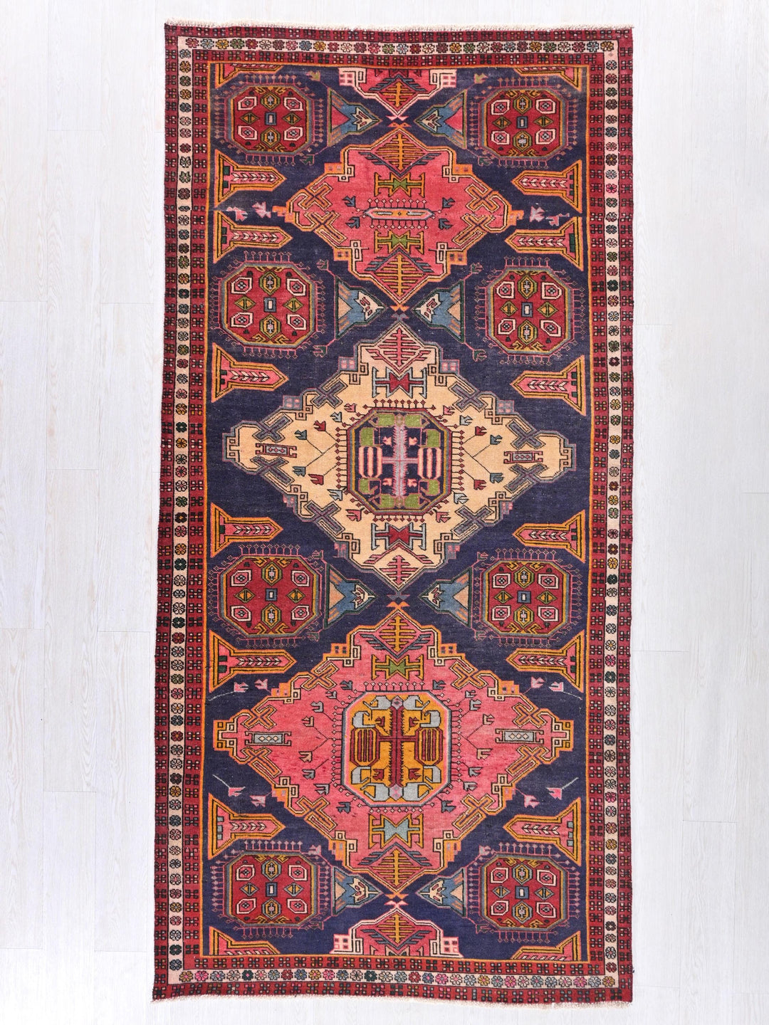 a multicolored rug hanging on a wall