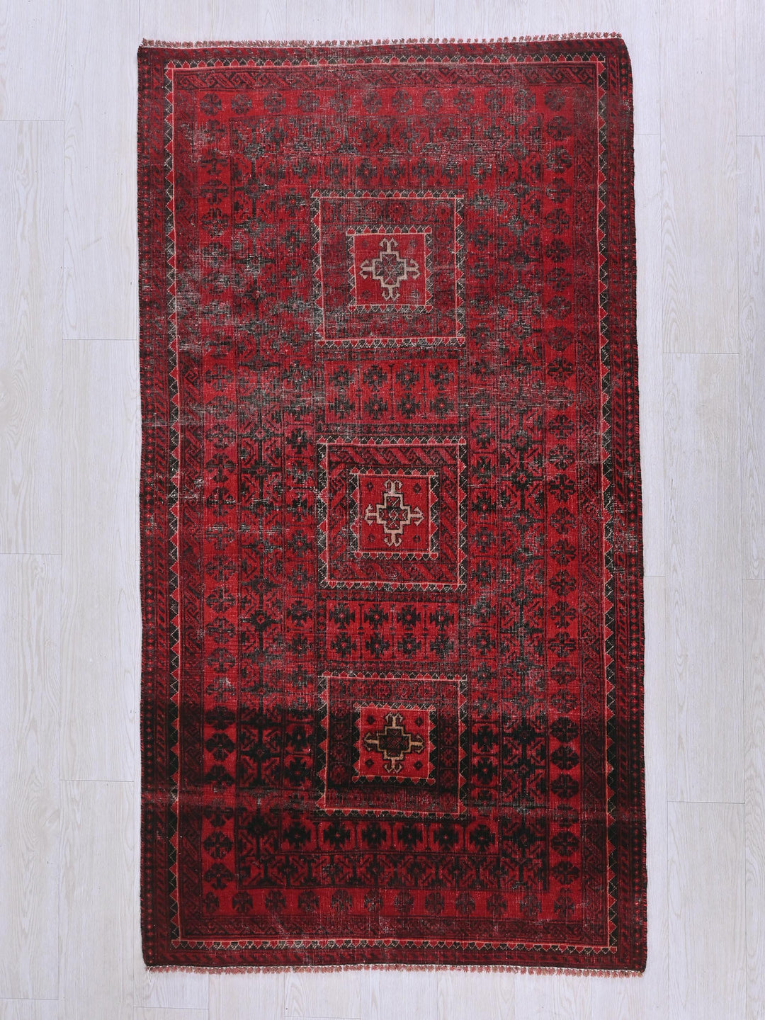 a red and black rug on a white floor