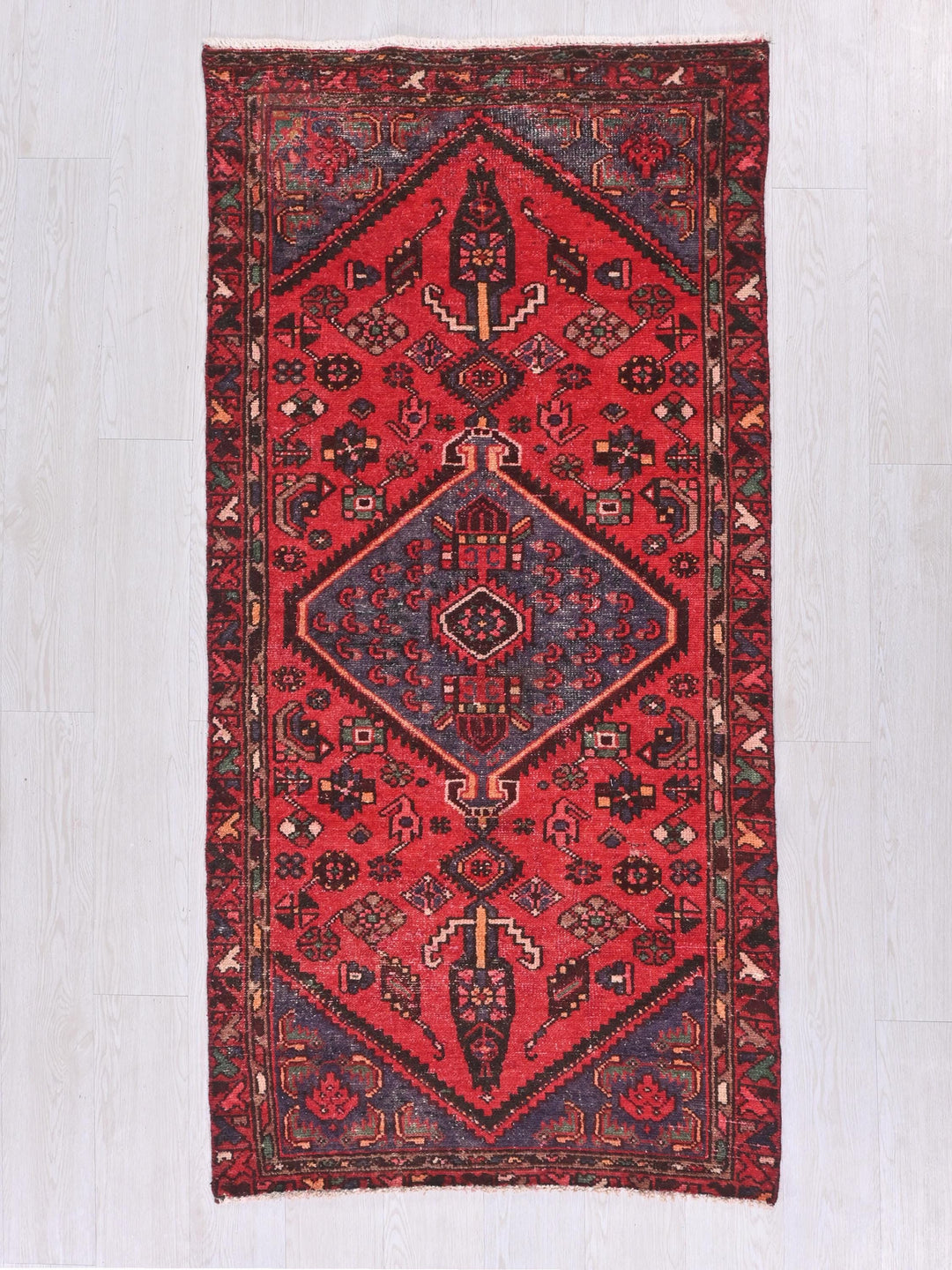 a red rug with a diamond shaped design