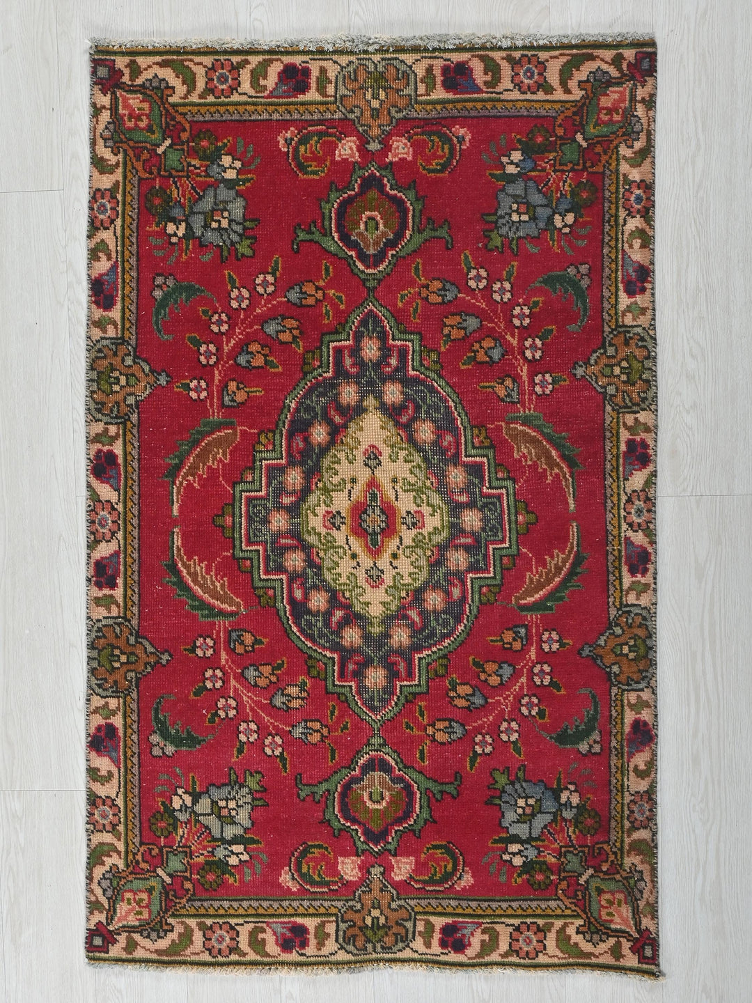 a red rug with a floral design on it