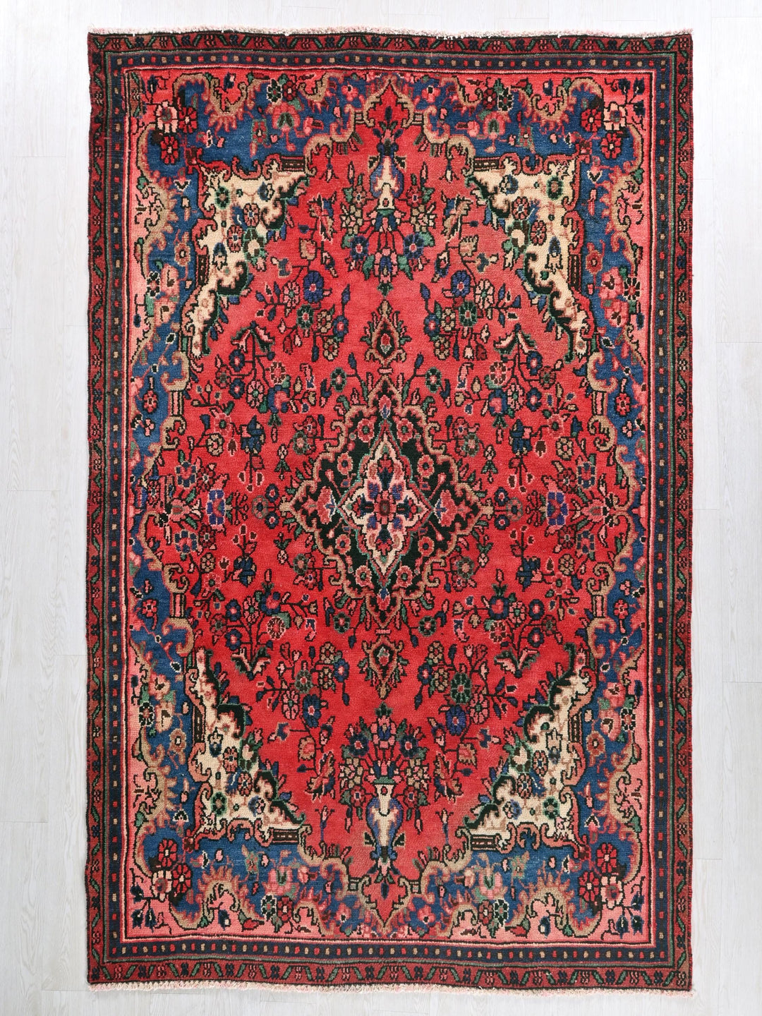 a red and blue rug with a floral design