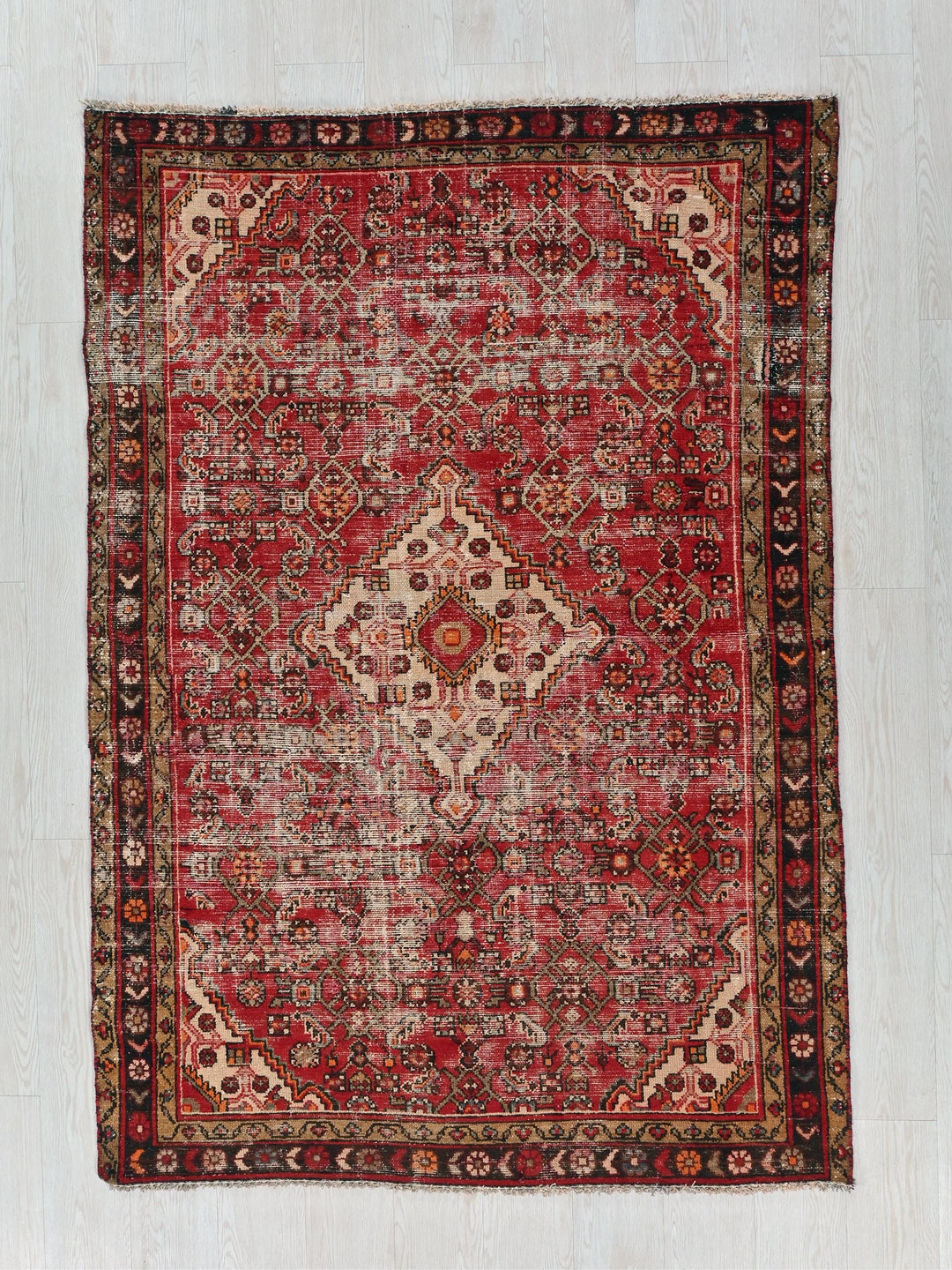 a red rug on a white wooden floor