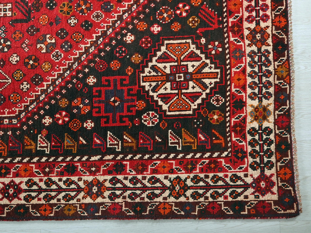 a red rug with a pattern of animals and flowers