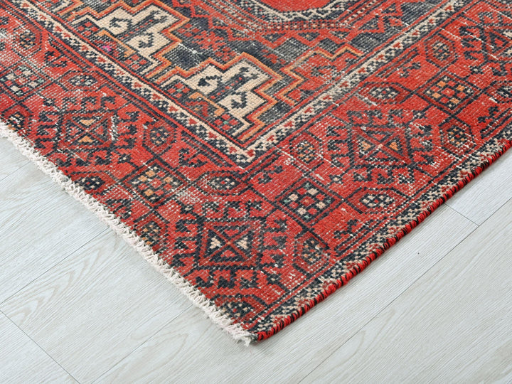 a red and black rug on a white floor