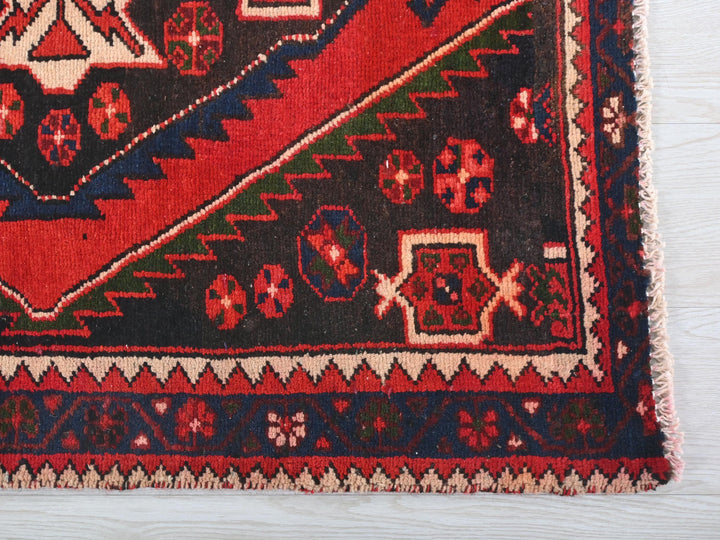 a red and blue rug on a white surface