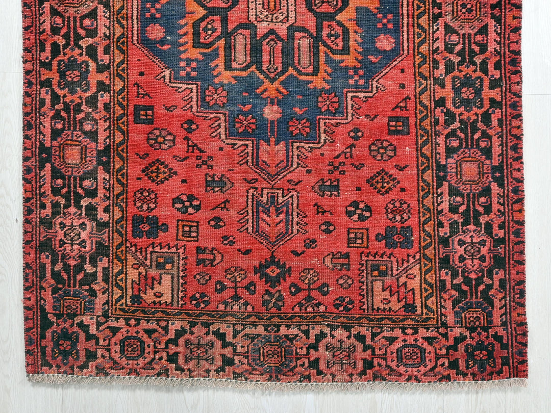 a red rug with a blue and orange design on it