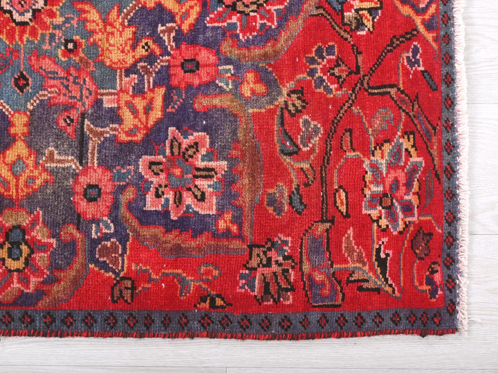 a red oriental rug with a blue border