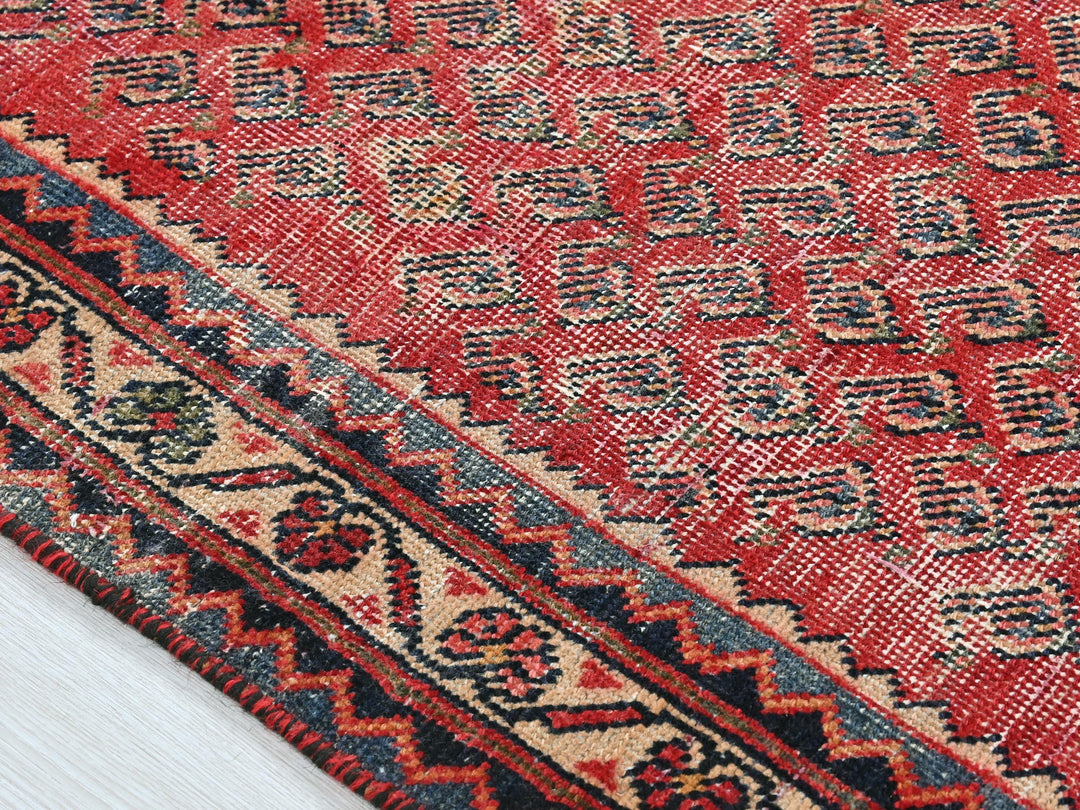 a close up of a red rug on a wooden floor