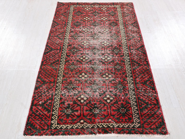 a red and black rug on a white floor