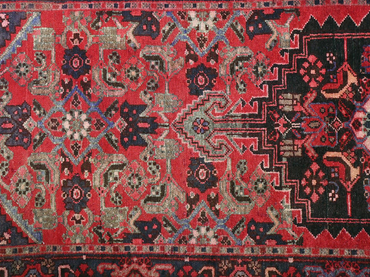 a red and black oriental rug with a design on it