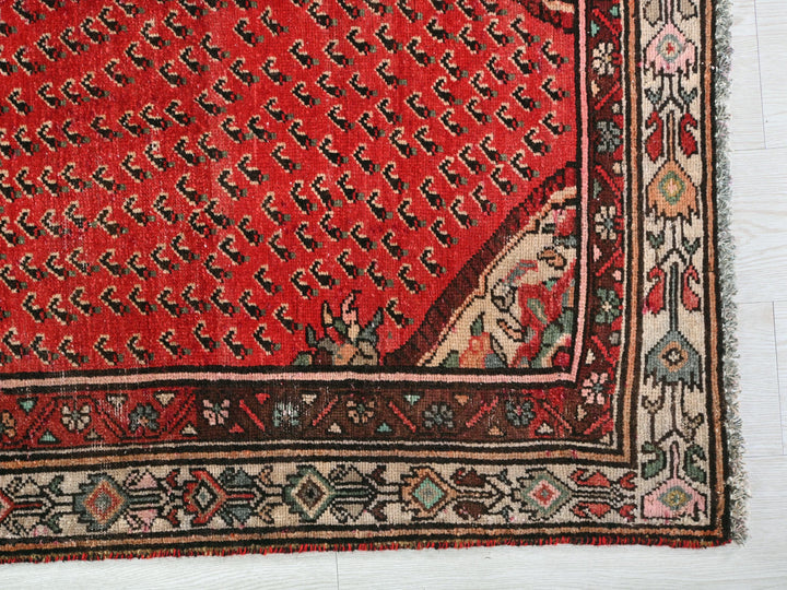 a red rug with a design on it
