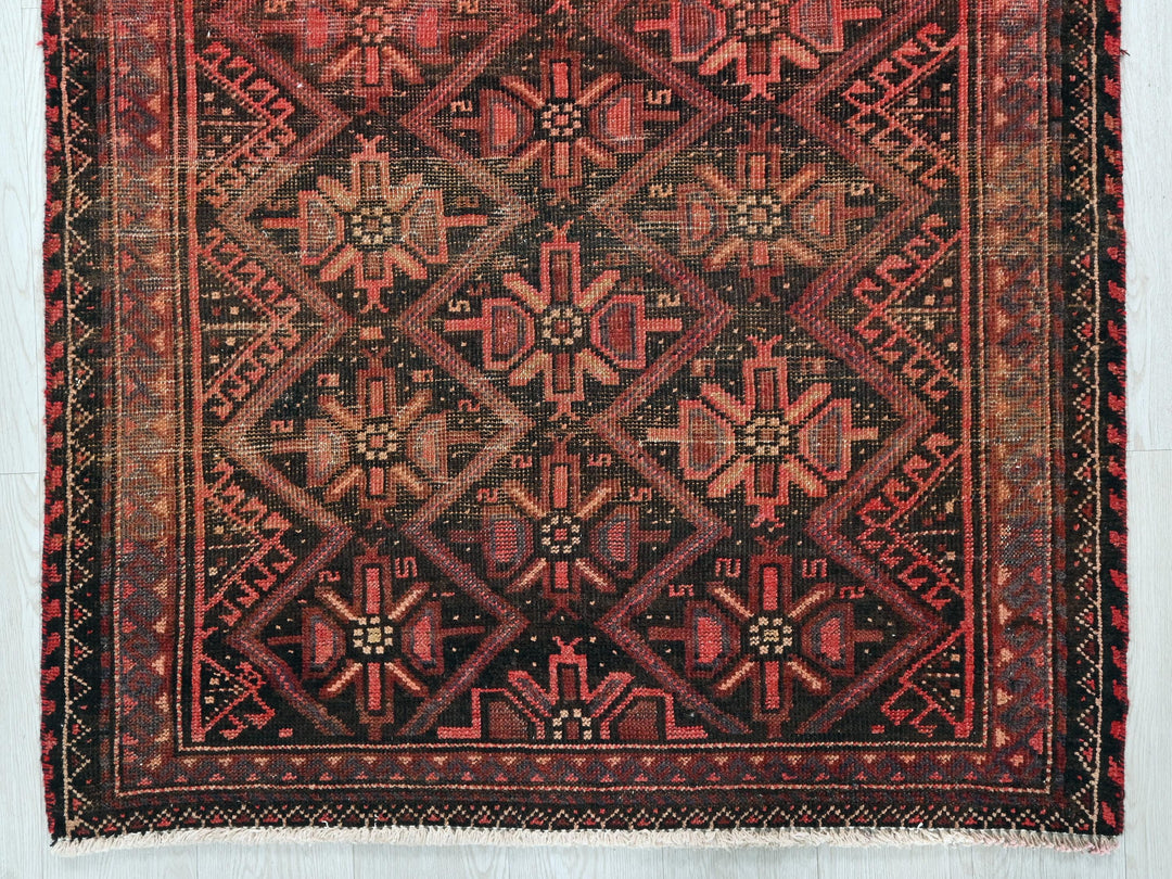 a red and black rug with a design on it