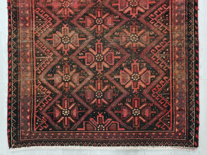 a red and black rug with a design on it