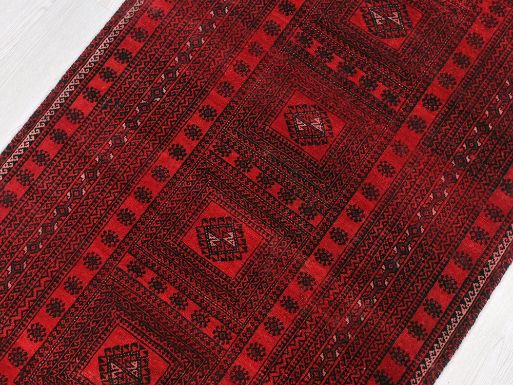 a close up of a red rug on a white floor