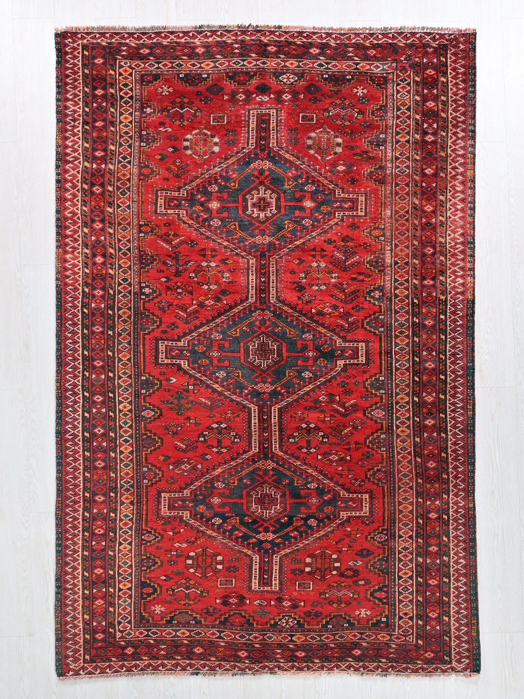 a red rug with a blue and red design on it
