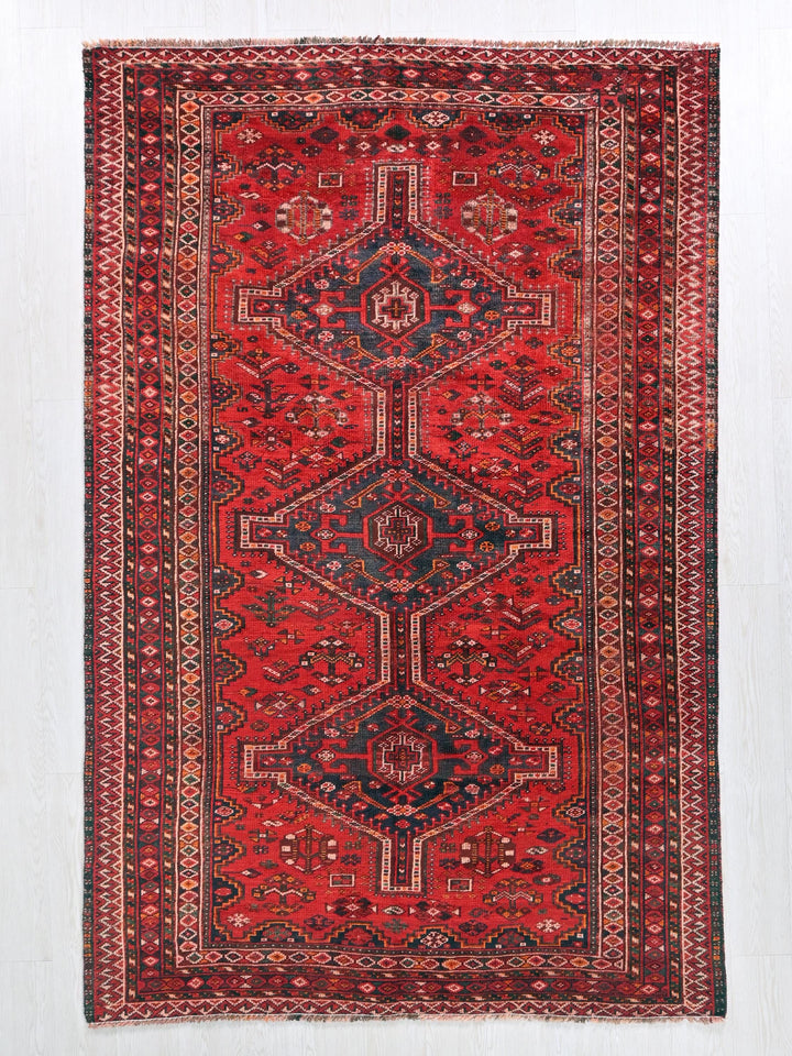 a red rug with a blue and red design on it