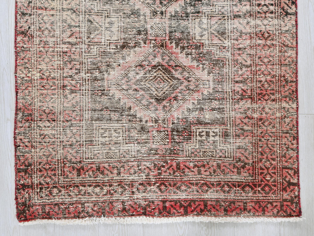 a red and black rug on a wooden floor