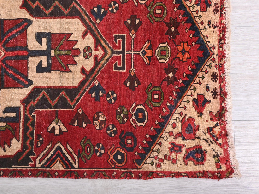 a red rug with a design on the middle of it
