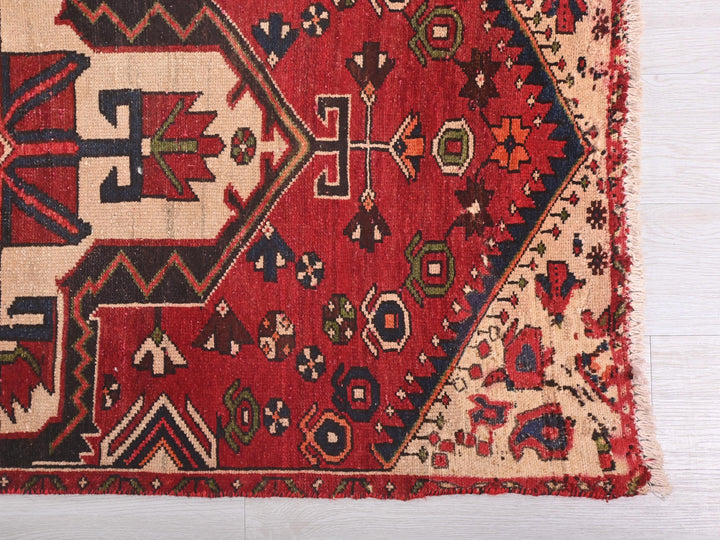 a red rug with a design on the middle of it