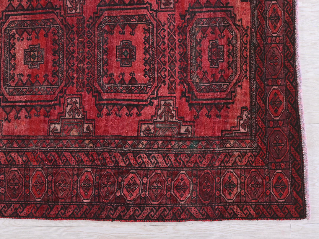 a red and black rug on a white surface