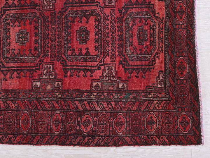 a red and black rug on a white surface
