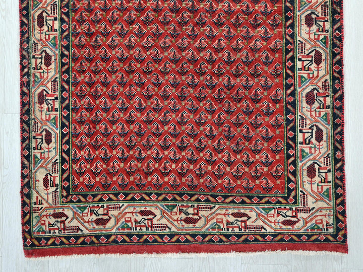a red and black rug on a white floor