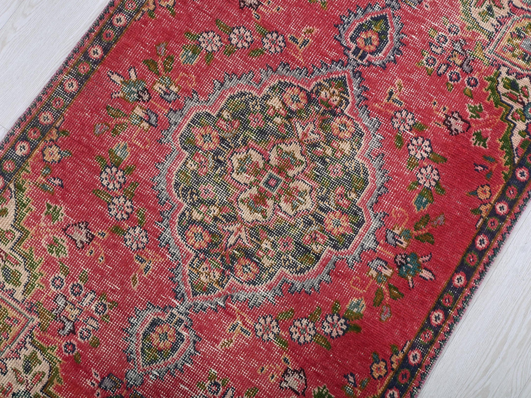 a red rug on a white wooden floor