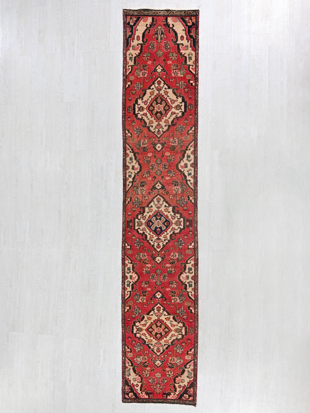 a long red rug hanging on a wall