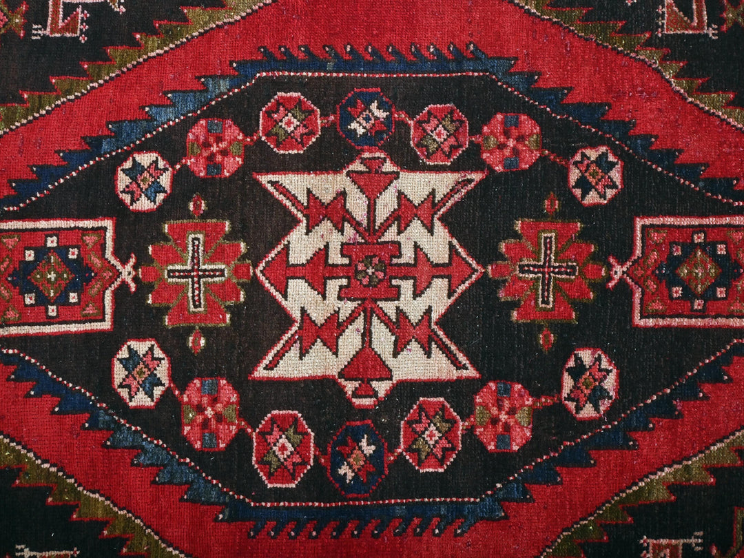 a close up of a red and black oriental rug
