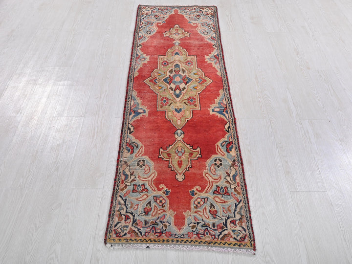 a long red rug on a white floor