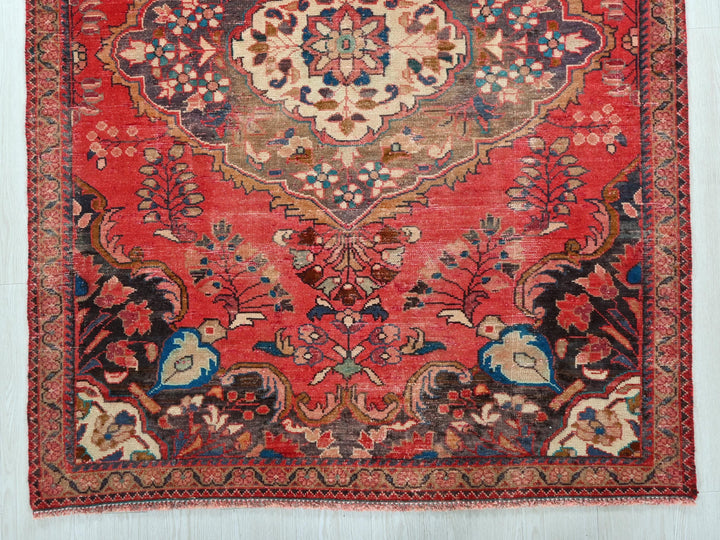a red rug with a floral design on it
