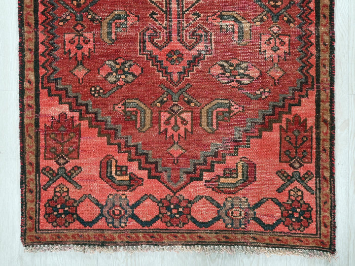 a red rug with a design on the middle of it