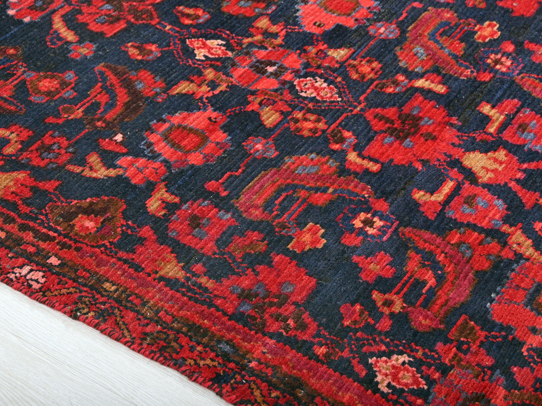 a red and black oriental rug on a white floor