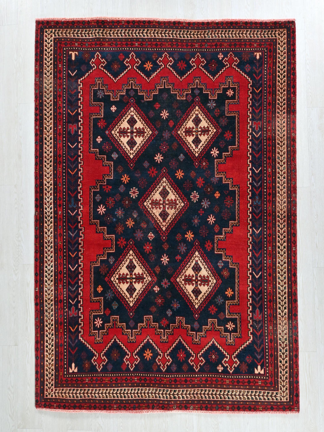 a red and black rug on a white floor