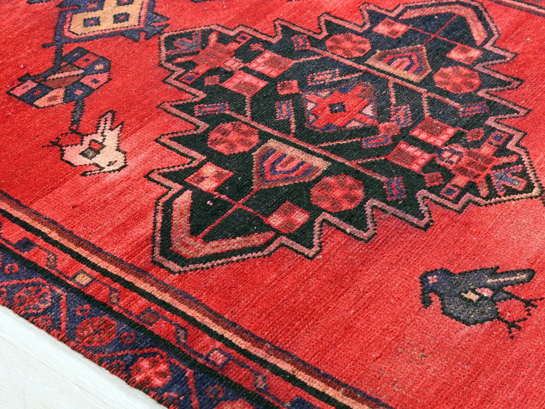 a red rug with a black and blue design on it