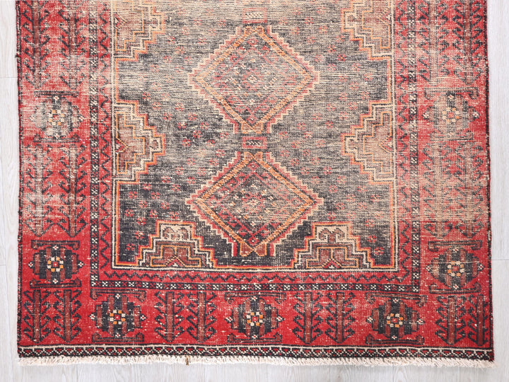 a red rug with a diamond pattern on it