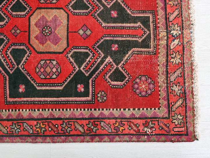 a red and black oriental rug on a white background