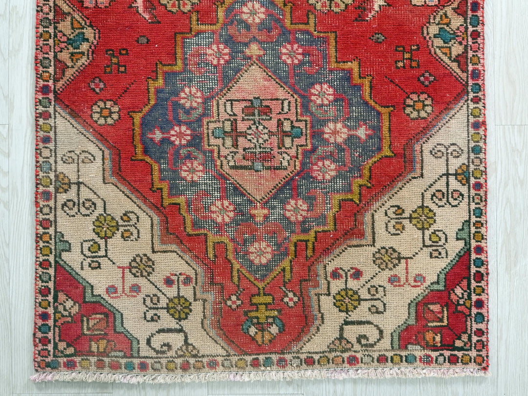 a red and blue rug on a wooden floor