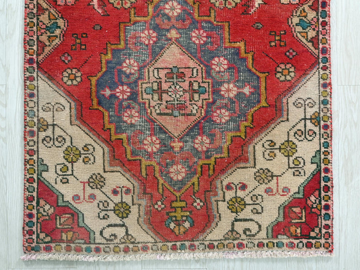 a red and blue rug on a wooden floor