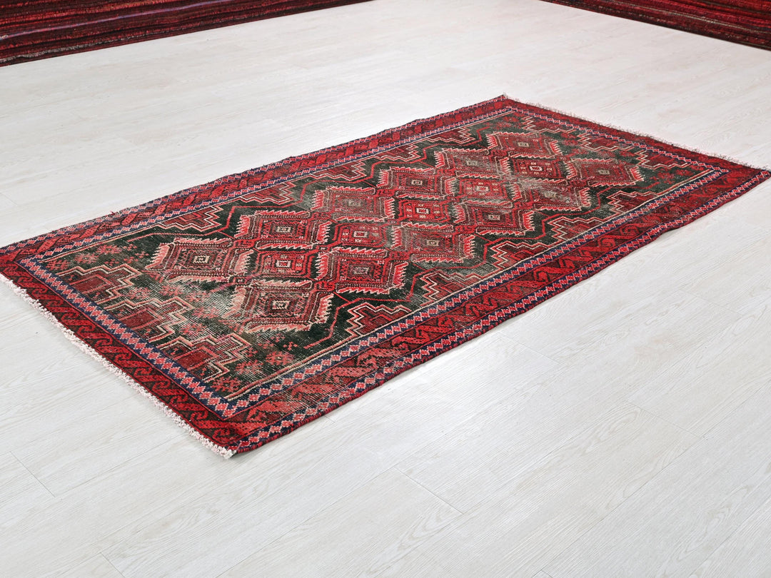 a red and black rug on a white floor
