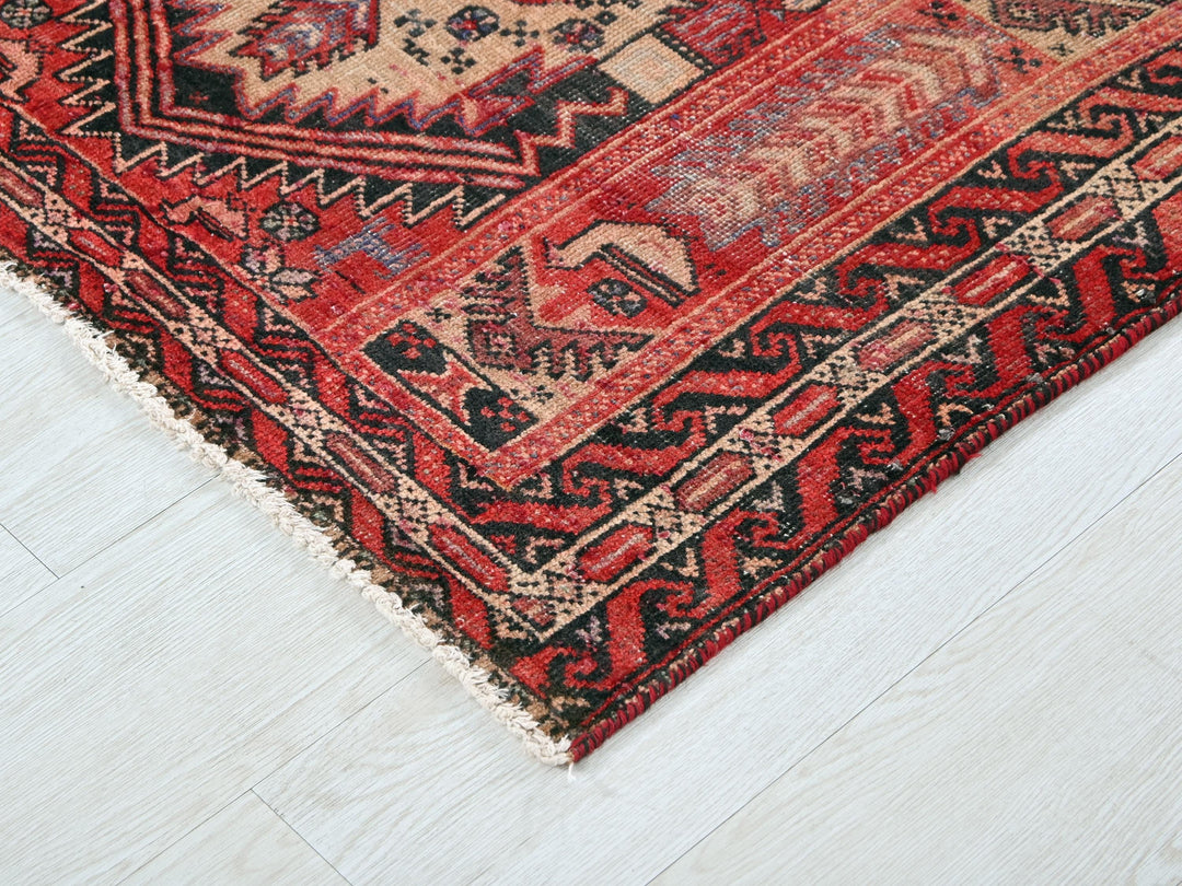a red and black oriental rug on a white floor
