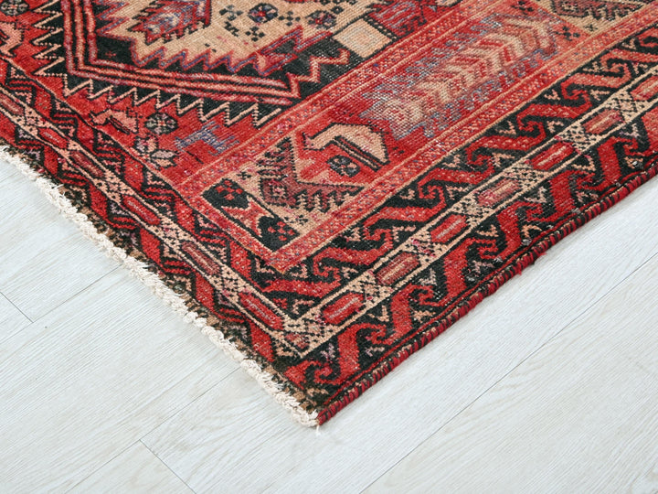 a red and black oriental rug on a white floor